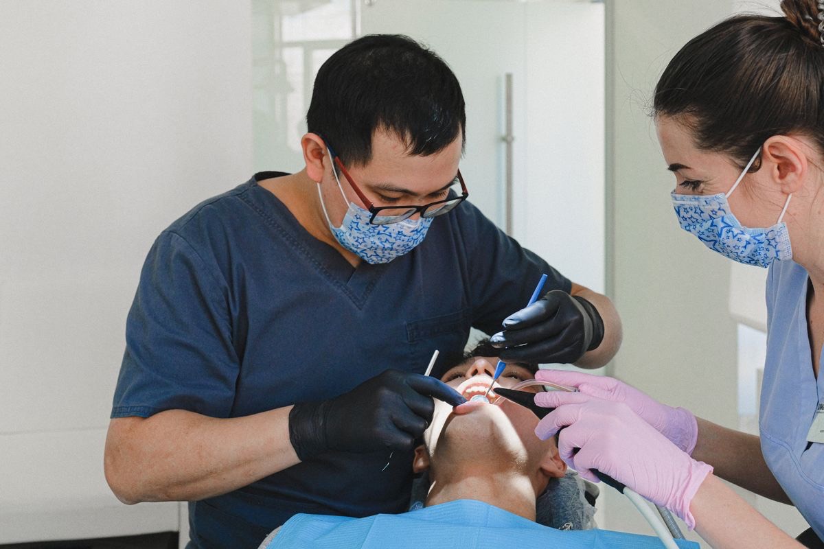 Dentists performing a routine dental check-up on a patient